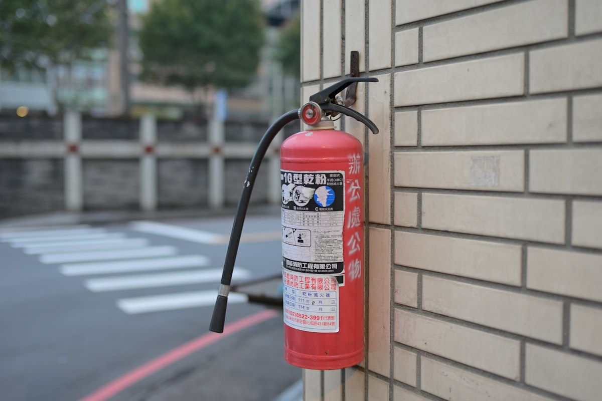 Red fire extinguisher mounted on a brick wall.